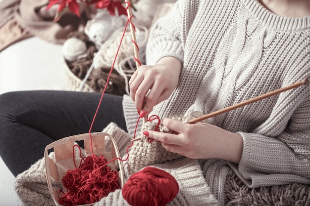 woman knits knitting needles on the couch