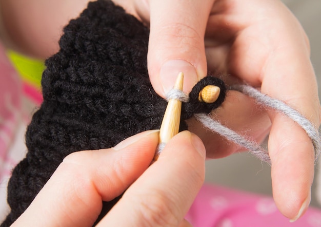 Photo woman knits on the needles closeup. the production of clothing hand made