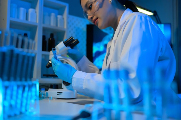 Photo a woman in a lab coat is holding a microscope slide