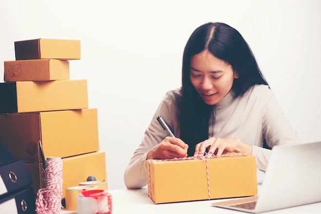 Woman labeling moving box at home