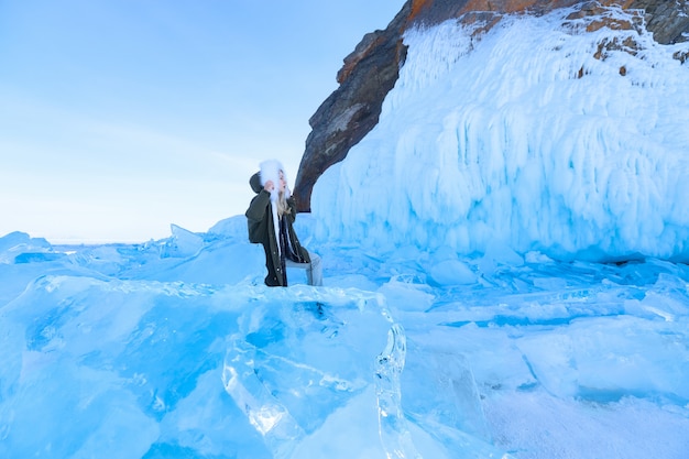 Foto donna sul lago baikal tra ghiaccio e rocce di neve