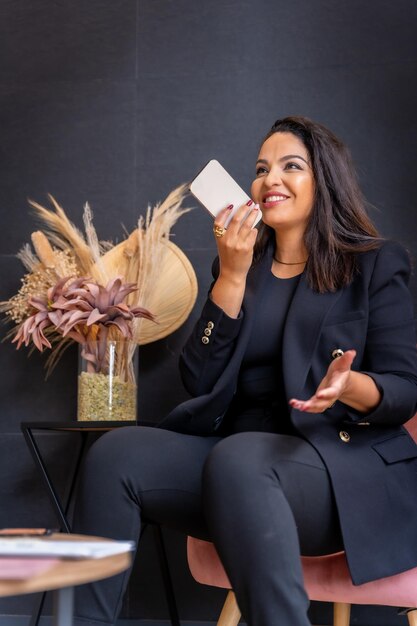 Woman of Latin ethnicity in an aesthetic store of eyebrows and nails Female boss talking on the phone in the waiting room