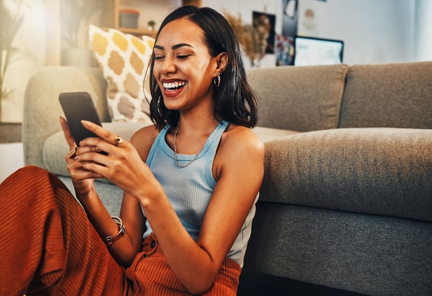 Woman laughing at chat on smartphone social media and funny meme with communication and technology Female person relax at home using phone and comedy online with streaming and texting on app