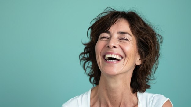 A woman laughing with her eyes closed