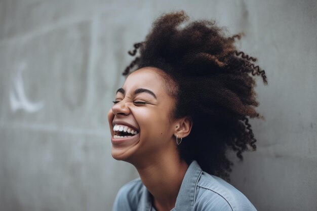 A woman laughing with her hair pulled back and her eyes closed.