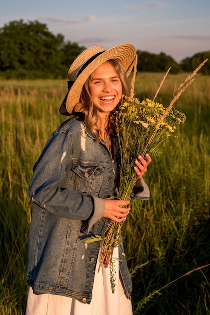 The woman laughs and holds a bouquet of wildflowers