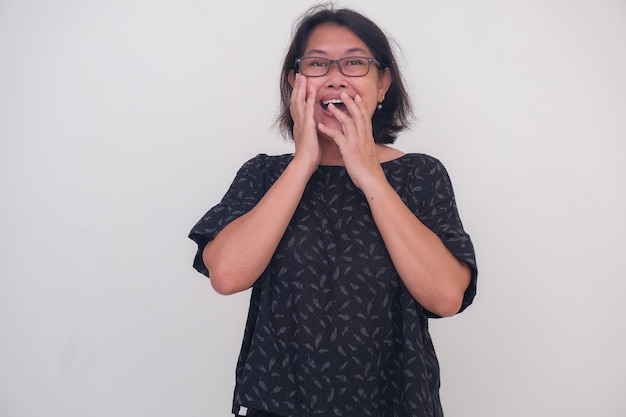 A woman laughs with a surprised expression while covering her mouth