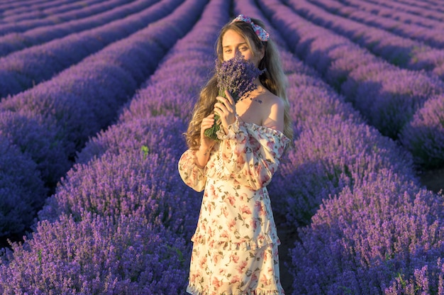 Woman in lavender field at sunset wearing summer dress