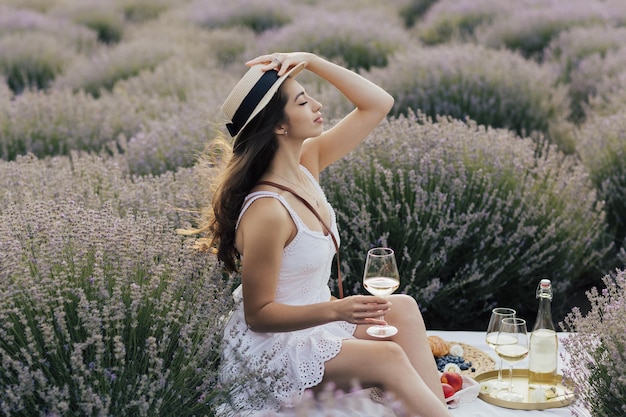 Woman in a lavender field with a straw hat