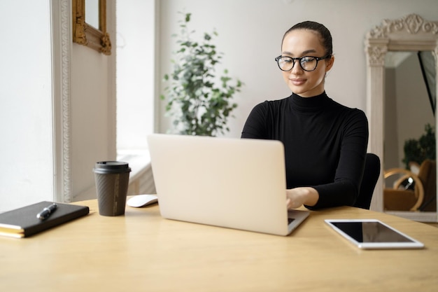 사무실에서 노트북을 사용하는 여성 변호사가 동료 컴퓨터 안경에 메시지를 씁니다.