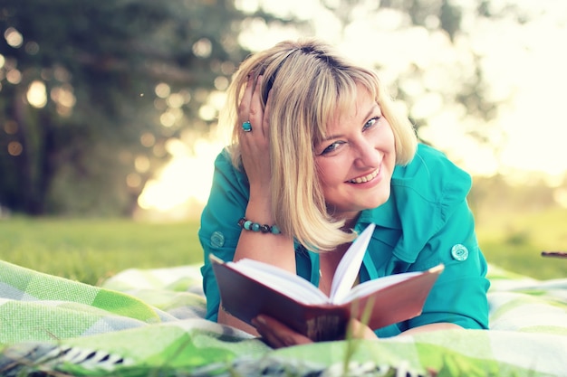 Photo woman lay and read book sun