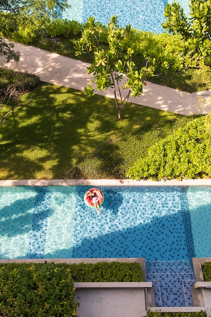 Woman laying  on balloon in swimming pool