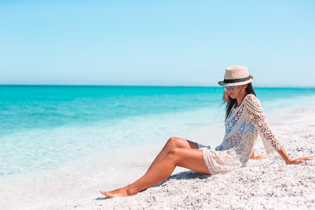 Woman laying on the beach enjoying summer holidays looking at the sea