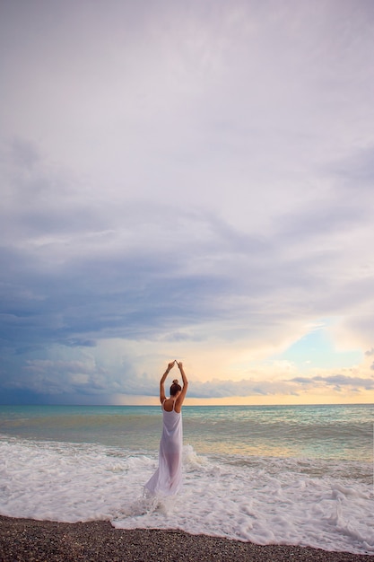 Woman laying on the beach enjoying summer holidays looking at the sea