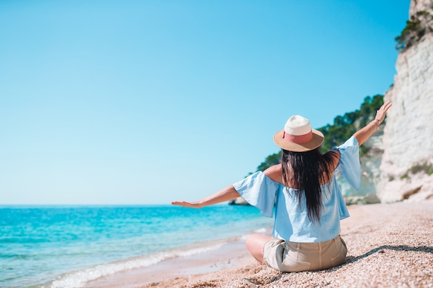 海を見て夏休みを楽しんでいるビーチに敷設する女性