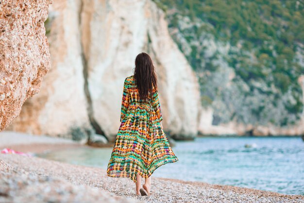 海沿いを歩く夏休みを楽しんでいるビーチに敷設する女性