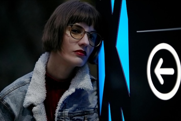 A woman leaning against a sign that says bmw.