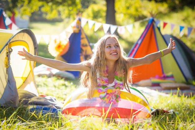 Woman leaning on beach ball at campsite