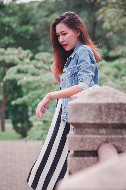 Woman leaning on a bridge in the park