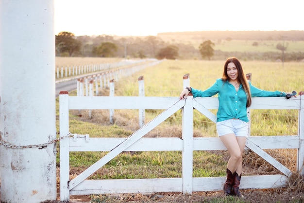 Woman leaning on the wooden gate