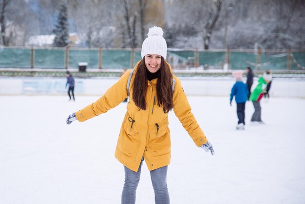 女性は都市のアイススケートリンクでスキーを学ぶ