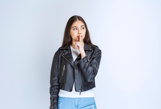 woman in leather jacket asking for silence.