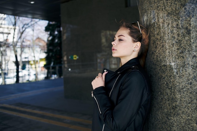 Woman in leather jacket on the street in the city and edition sunglasses in the background