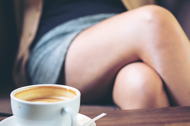 Woman leg and coffee cup