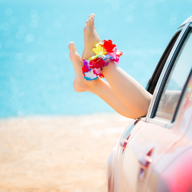 Woman legs against blue sea and beach background summer vacations concept