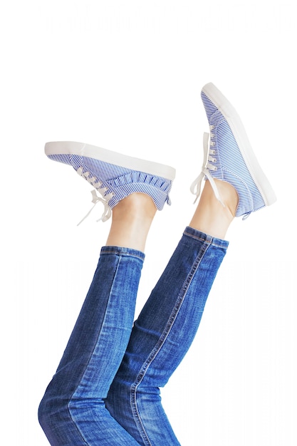 Женщина ноги в синих джинсах на белом фоне изолированные