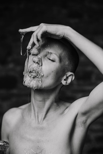 Woman licking liquid caramel on her face