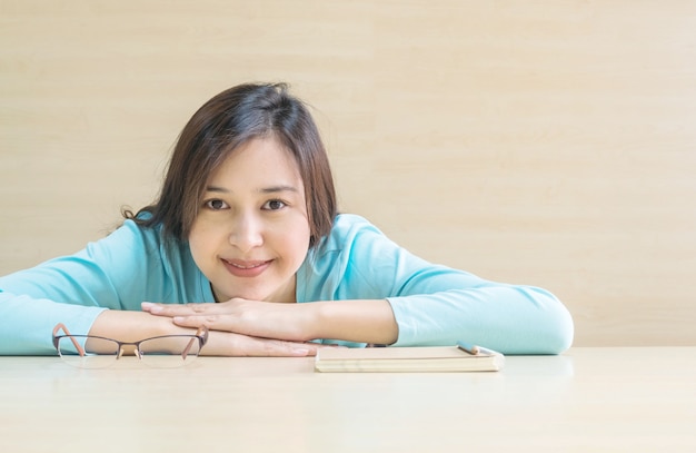 Woman lied on desk with happy face in rest time from reading a book