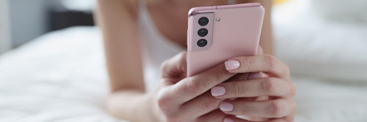 Photo 여자는 침대에 누워 스마트폰 근접 촬영을 본다