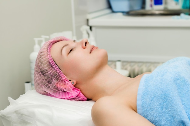 A woman lies down and prepares to undergo a cosmetic or clinical procedure