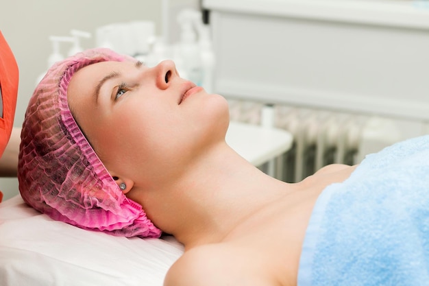 A woman lies down and prepares to undergo a cosmetic or clinical procedure