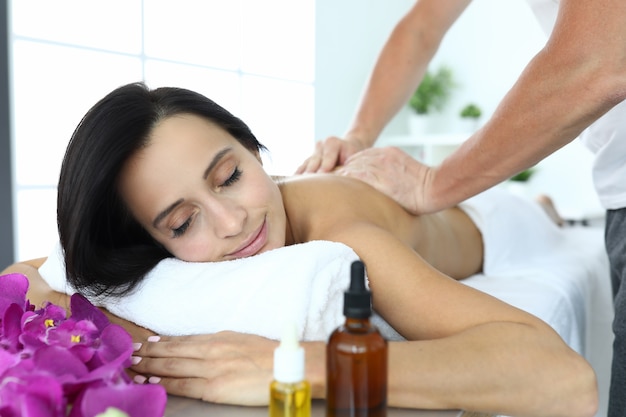 Woman lies on massage table she is being massaged.