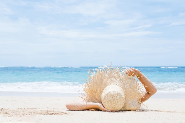 Woman lies on the white sand on the beach Summer and vacation concept