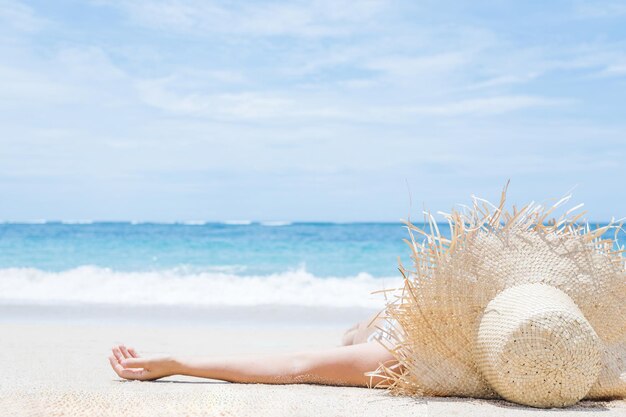 Женщина лежит на белом песке на пляже