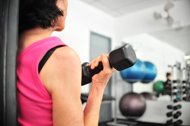 Foto donna che solleva i manubri in palestra