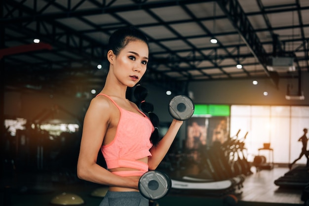 Woman lifting dumbbells in gym