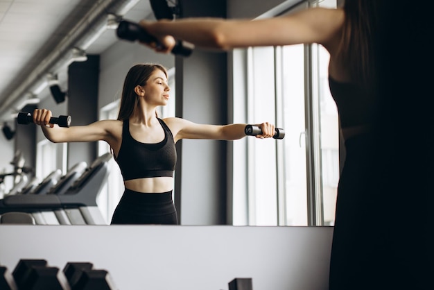 Donna di sollevamento manubri in palestra