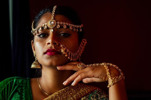 Woman lighting diyas with nuth nath nose piercing and the golden teak with traditionak fashion sari