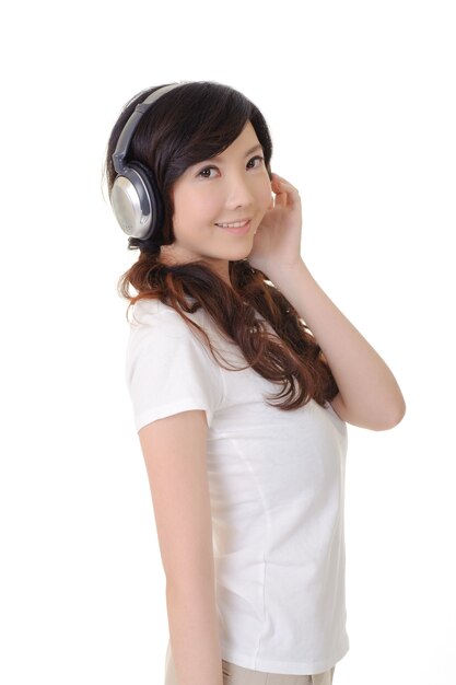 Woman listen music and looking at you, closeup portrait in white wall.