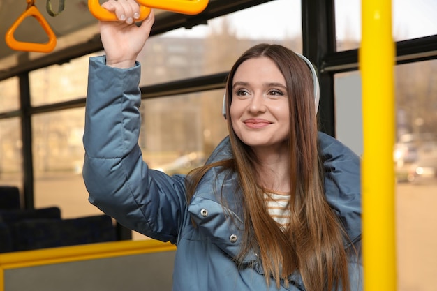 Photo woman listening to audiobook in trolley bus