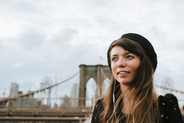 Photo woman listening to music on the brooklyn bridge, usa