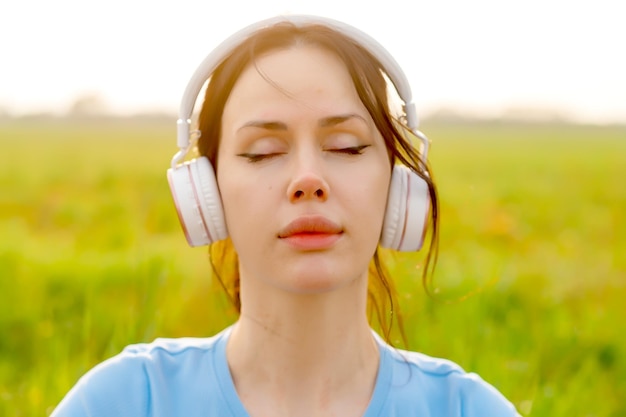 A woman in listening to music in headphones closing her eyes