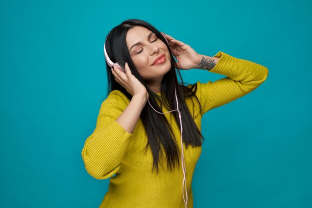 Woman listening music in headphones with closed eyes.