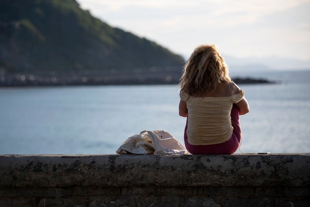 woman listening to music and looking at the sea