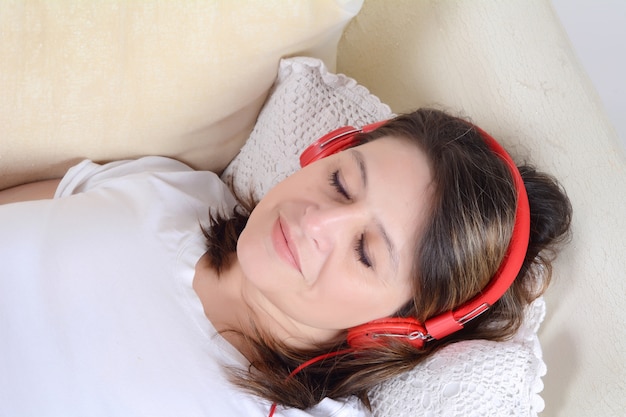 Woman listening to music on the sofa.