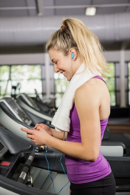 Photo woman listening to music on treadmill